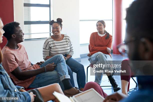 smiling young students sitting with instructor - social gathering photos et images de collection