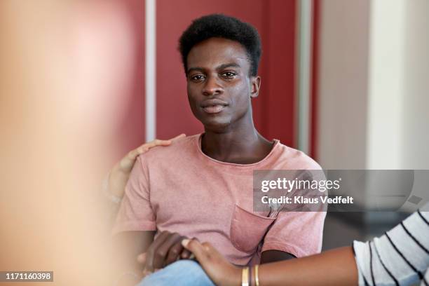 sad man crying while being consoled by friends - negatieve eigenwaarde stockfoto's en -beelden