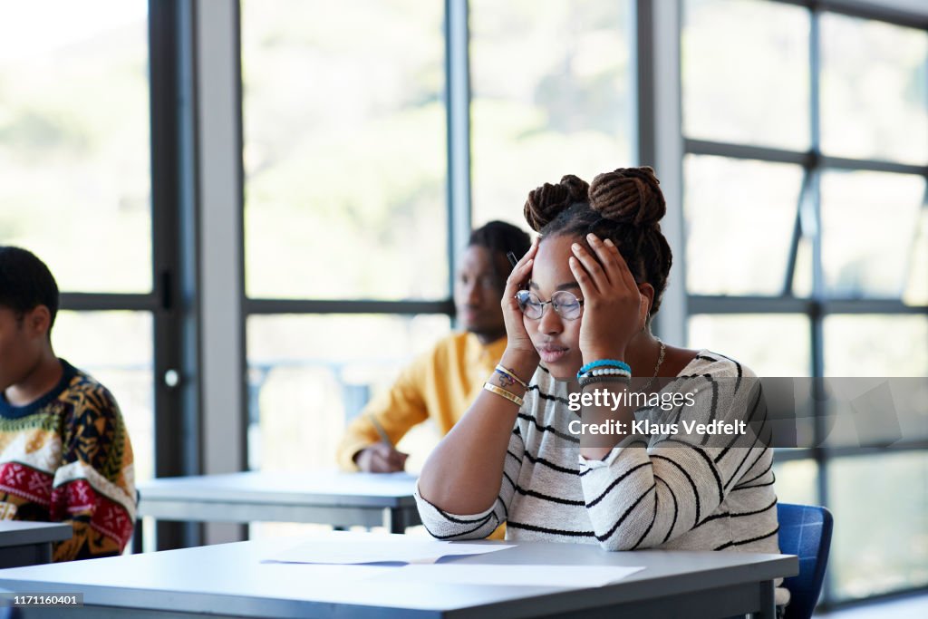 Worried student sitting with head in hands at desk