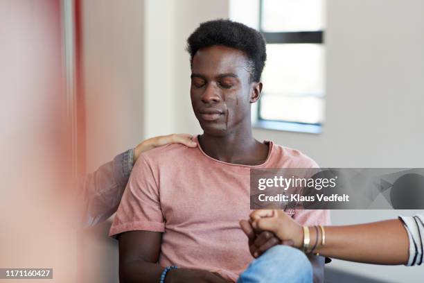 young female friends consoling sad crying man - crying stock pictures, royalty-free photos & images