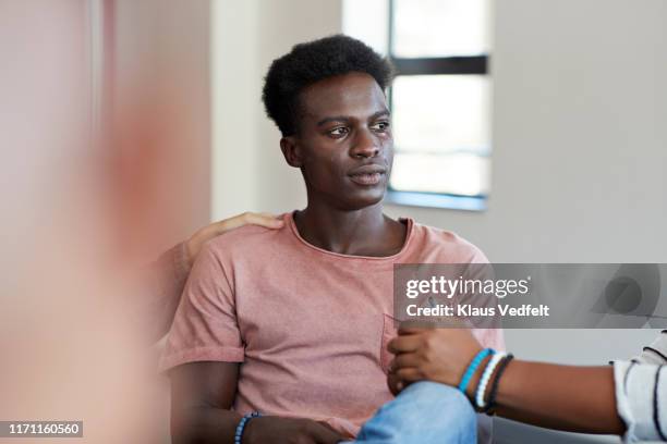 young man crying while being consoled by friends - african american man depressed bildbanksfoton och bilder