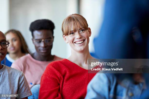 smiling woman looking at professor in classroom - male student wearing glasses with friends stockfoto's en -beelden