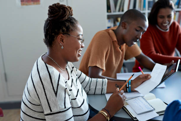 Top 10 Best Universities in Tanzania You Need to Consider 1 smiling female student reading paper by friends