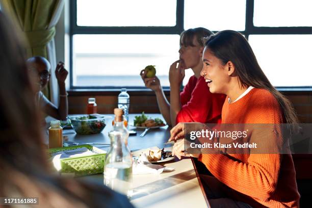 smiling woman enjoying lunch with friend at table - school lunch foto e immagini stock