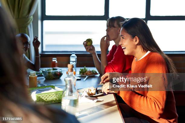 smiling woman enjoying lunch with friend at table - lunchpauze stockfoto's en -beelden