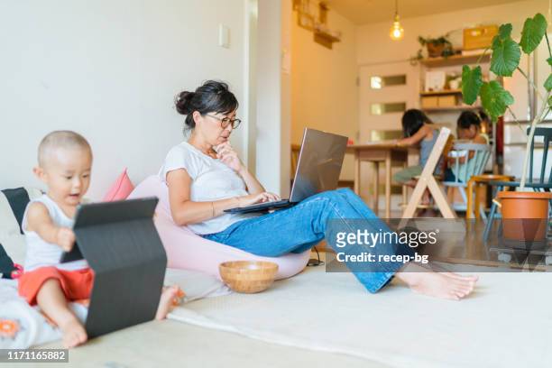 Mother working on laptop at home