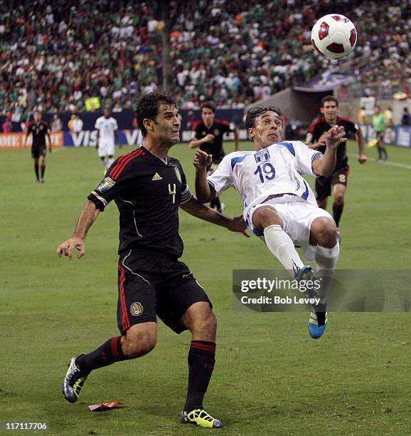 Javier Portillo of Honduras clears the ball away from Rafael Marquez of Mexico in the first half at Reliant Stadium on June 22, 2011 in Houston,...