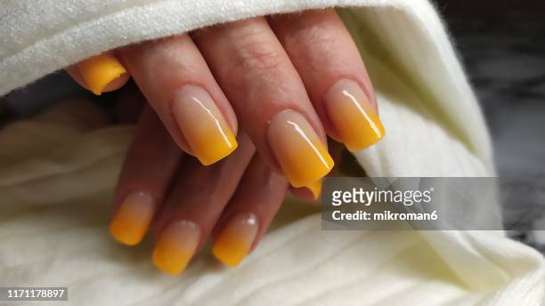 close-up of woman fingers with nail art manicure with yellow - ombre stock-fotos und bilder