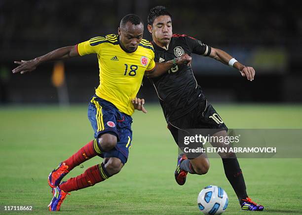 Colombia's Camilo Zuniga vies for the ball with Mexico's Marco Fabian during their friendly football match at the 'Hernan Ramirez Villegas' stadium,...