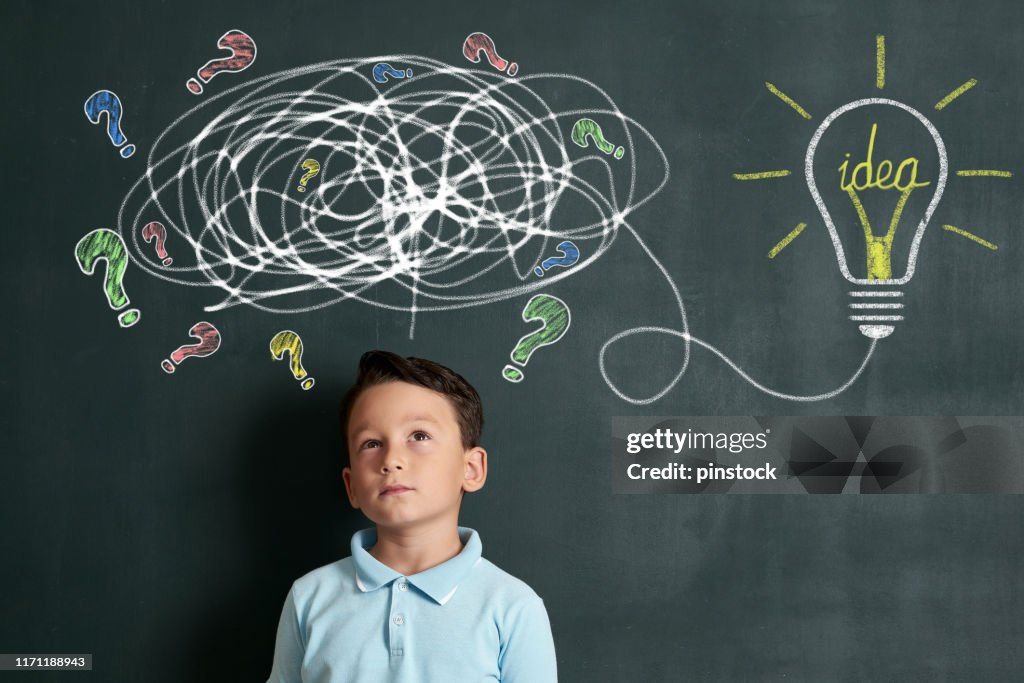 6-7 years child is finding solution on front of blackboard