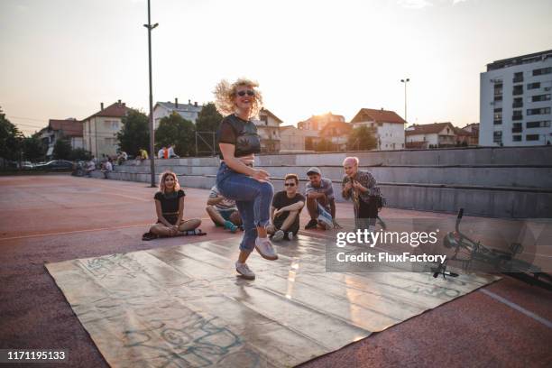 hip-hop girl dancing in front of friends outdoors on a sports court - hip hopper stock pictures, royalty-free photos & images