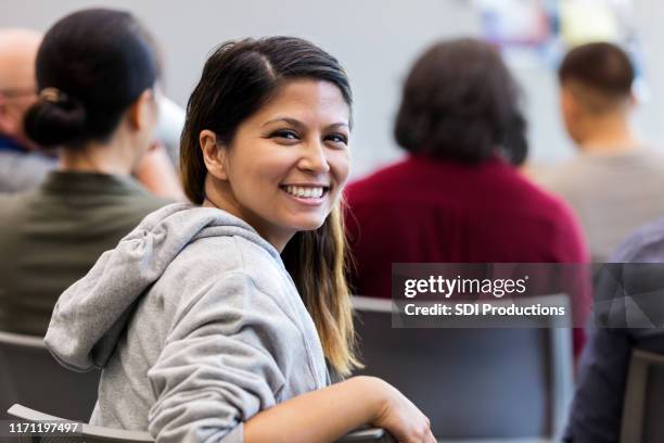 während des seminars, mittelerwachsene frau dreht sich um, um vor der kamera zu lächeln - smile black white stock-fotos und bilder