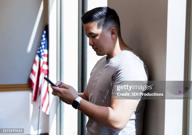 mid adult veteran takes time from meeting to text wife - cell phones for soldiers stock pictures, royalty-free photos & images
