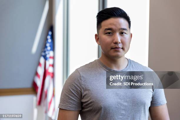 portrait of serious veteran with american flag in background - army shirt stock pictures, royalty-free photos & images