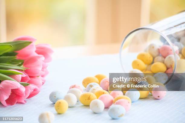 easter eggs fallen from a glass jar and tulips bouquet - easter background stock pictures, royalty-free photos & images