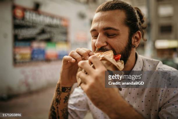 street food - eating sandwich stock-fotos und bilder