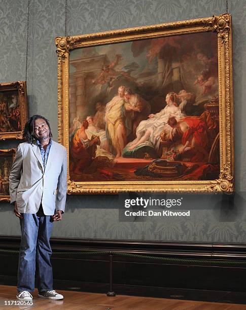 Artist Yinka Shonibare MBE poses besides a painting by Jean-Honore Fragonard entitled 'Psyche showing her Sisters her Gifts from Cupid', at The...