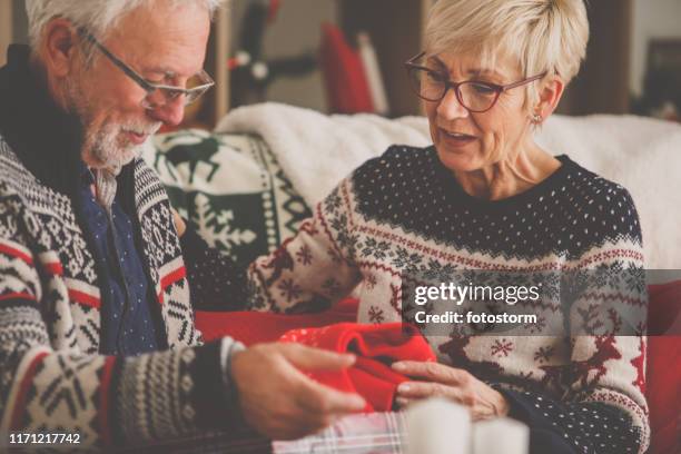 senior couple opening christmas gifts - matching outfits stock pictures, royalty-free photos & images