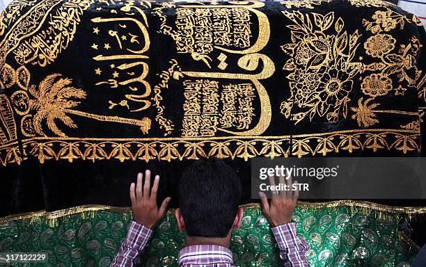 An Indian devotee prays at the ancient shrine of Dalip Singh Baba Chamliyal during the annual fair at at the Pakistan-India border at Ramgarh, about...