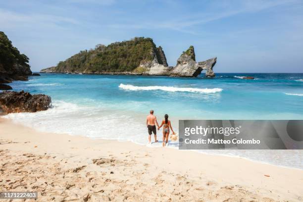 tourist couple at the beach, nusa penida, bali - bali beach ストックフォトと画像