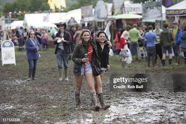 Festival goers walk through mud at the Glastonbury Festival site at Worthy Farm, Pilton on June 22, 2011 in Glastonbury, England.