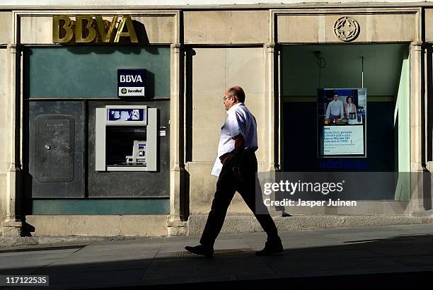 Man passes a bank office on June 23, 2011 in Madrid, Spain. Eurozone finance ministers are currently seeking to find a solution to Greece's pressing...
