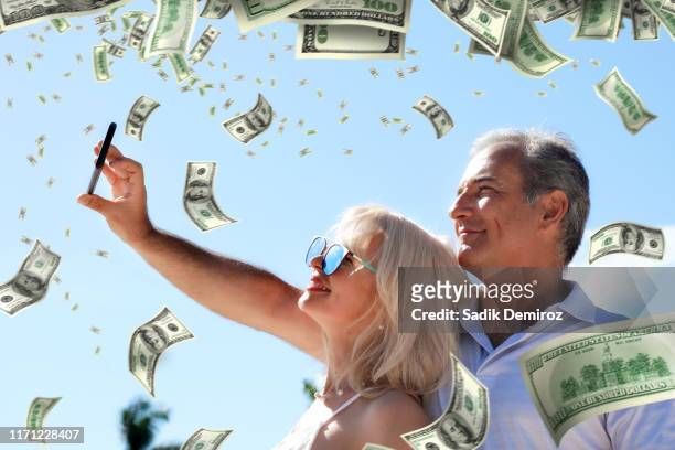 portrait middle age adult couple and falling large group of money - recordbrekend stockfoto's en -beelden