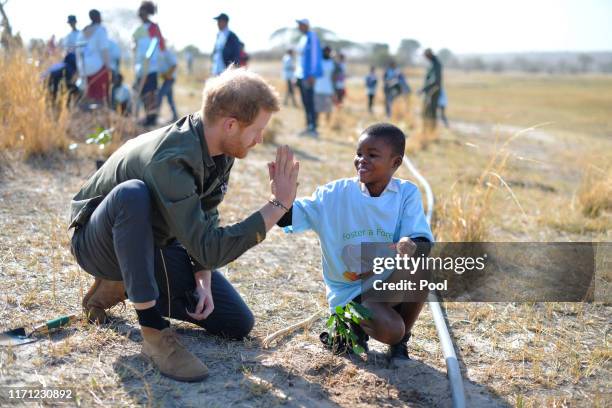 Prince Harry, Duke of Sussex helps local schoolchildren plant trees at the Chobe Tree Reserve in Botswana, on day four of their tour of Africa on...