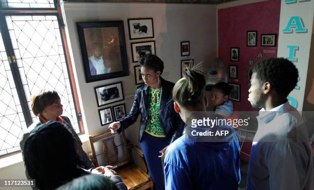 First lady Michelle Obama tours a recreated barber shop as she visits the District Six museum, in Cape Town, South Africa, June 23, 2011. Founded in...