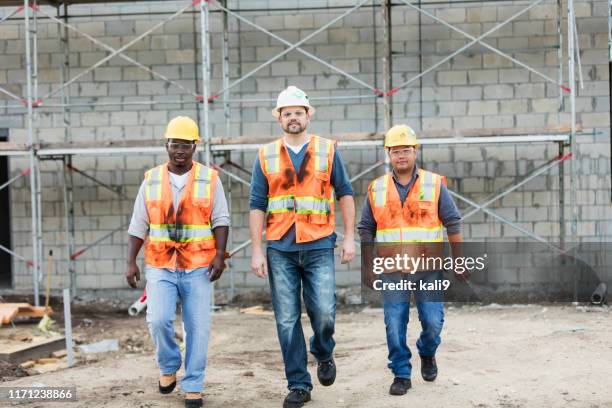 three construction workers walking toward the camera - construction worker walking toward camera stock pictures, royalty-free photos & images