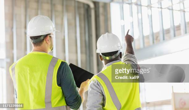 zwei bauarbeiter mit digitalem tablet - construction worker manager stock-fotos und bilder