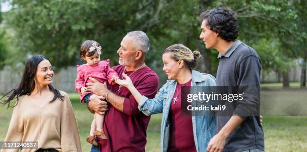 multi-generation hispanic family, looking at baby girl - necklace stock pictures, royalty-free photos & images