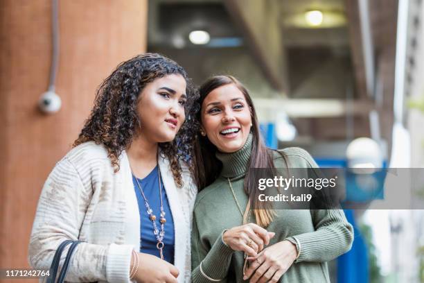 mixed race mother and teenage daughter waiting for train - purse contents stock pictures, royalty-free photos & images