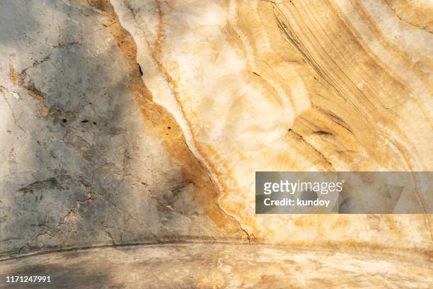 abstract background from yellow marble texture on wall with sunlight. - solid gold fotografías e imágenes de stock