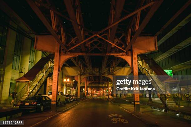 view of downtown of streets under metro at night - chicago street stock pictures, royalty-free photos & images