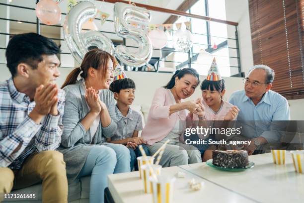 famiglia festeggia compleanno nonne insieme - parents children blow candles asians foto e immagini stock