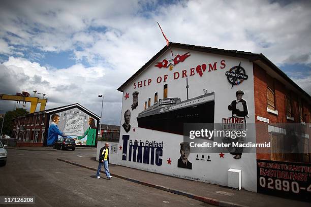Man walks past a mural celebrating the building of The Titanic at nearby Harland and Wolff shipyard in the mainly protestant area of East Belfast on...