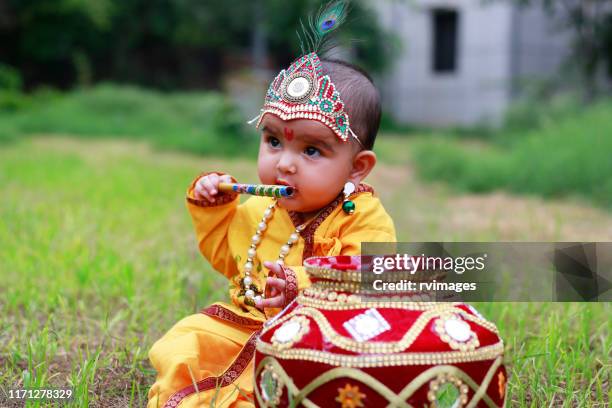 pequeña krishna con flauta - krishna janmashtami fotografías e imágenes de stock