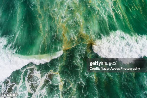 aerial view of waves splashing in sea. - new zealand aerial stock pictures, royalty-free photos & images