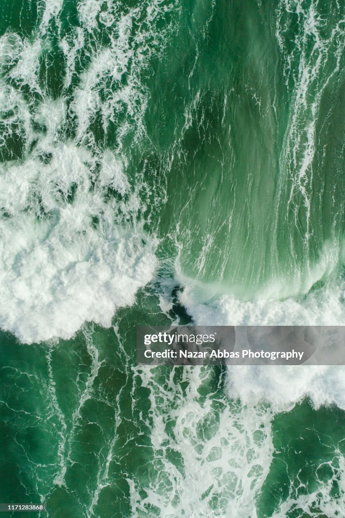 Aerial view of waves splashing in sea.
