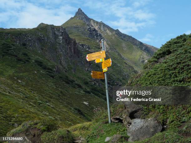 trail markers along hiking trail in bedretto valley - wegweiser schweiz stock-fotos und bilder