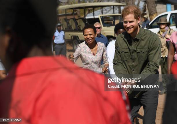 Prince Harry, Duke of Sussex reacts on his arrival at The Princes' foundation for children in Africa, Sentebale, at the Chobe district, in the...