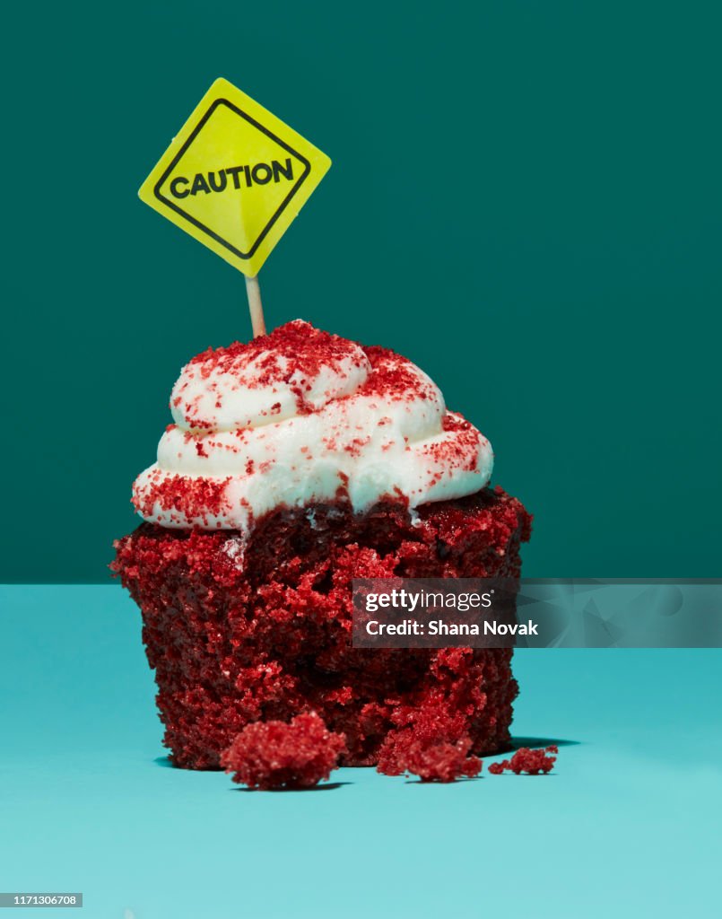 Half Eaten Cupcake with Caution Sign