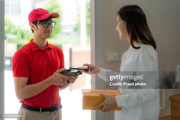 asian woman with smartphone using qr application for delivery payment with she receive the customer box at home. - send parcel stock pictures, royalty-free photos & images