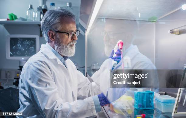scientist working in the fume hood - volume fluid capacity stock pictures, royalty-free photos & images
