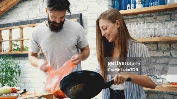 pareja joven haciendo la cena juntos en casa - kitchen after party fotografías e imágenes de stock