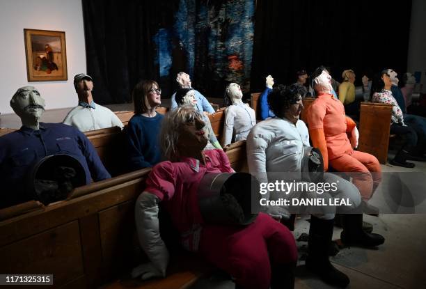 An employee poses for a photograph with an artwork entitled Collective Conscience by Colombian artist Oscar Murillo, during the press view of the...