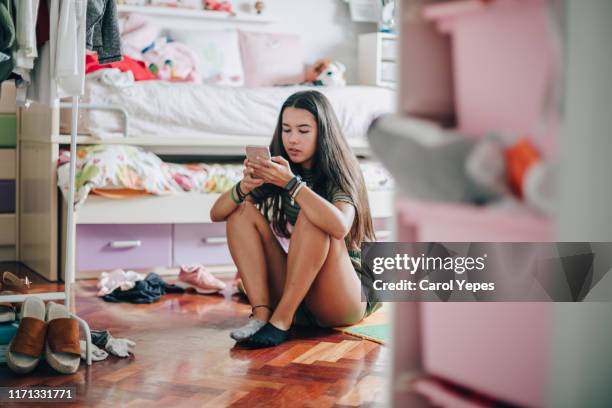 teen female using mobile device at home - casa real española fotografías e imágenes de stock