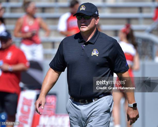 Head coach Mike Houston of the East Carolina Pirates watches his team warm up before their game against the North Carolina State Wolfpack at...
