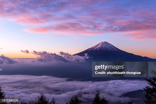 fuji mountain and the mist over lake kawaguchiko at beautiful sunrise , yamanashi, japan, mount fuji or fujisan located on honshu island, is the highest mountain in japan. - mt fuji stock-fotos und bilder